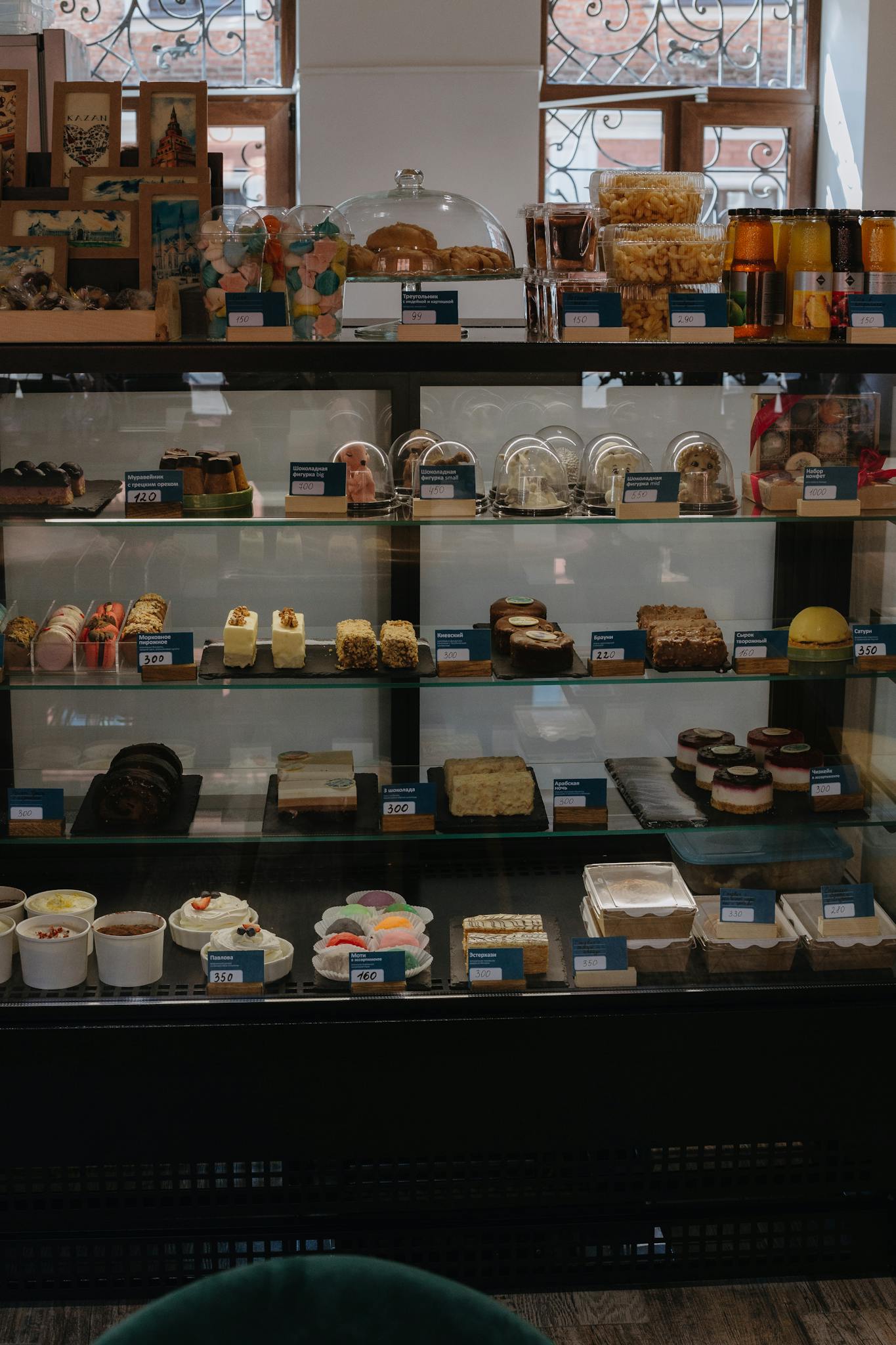 A bakery display case filled with various pastries and desserts in a retail setting.