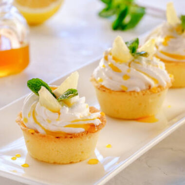 Tartlets with lemon kurd and italian meringue on a white plate close up