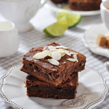 Brownie cake with almond flakes and cup of tea closeup