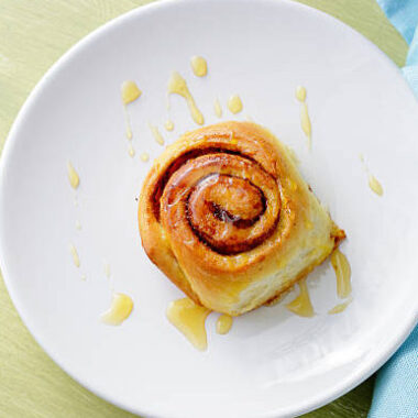 Cinnamon buns with honey on plate, top view
