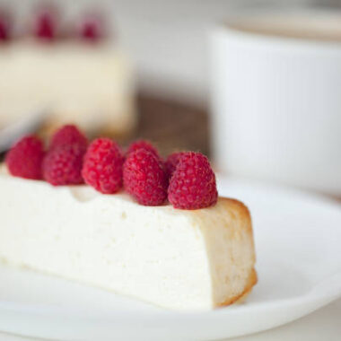 Slice of cheesecake with raspberry and cup of coffe. healthy breakfast.